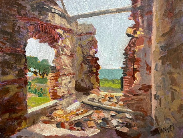 Vista interior de una antigua estructura en ruinas, con paredes de piedra y una abertura que da al paisaje natural, donde se puede ver vegetación verde y un cielo despejado.