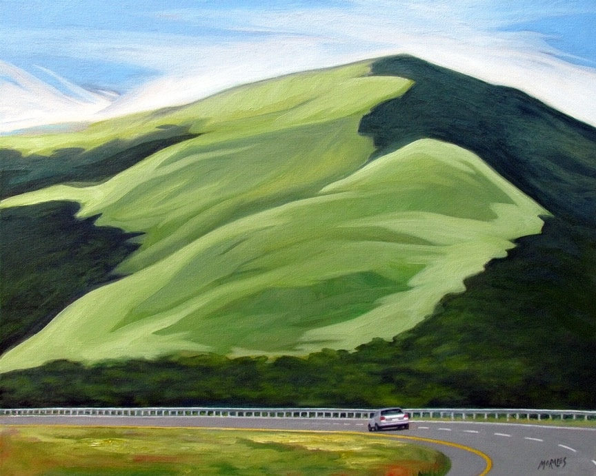 Paisaje montañoso con colinas verdes y un automóvil en una carretera curva