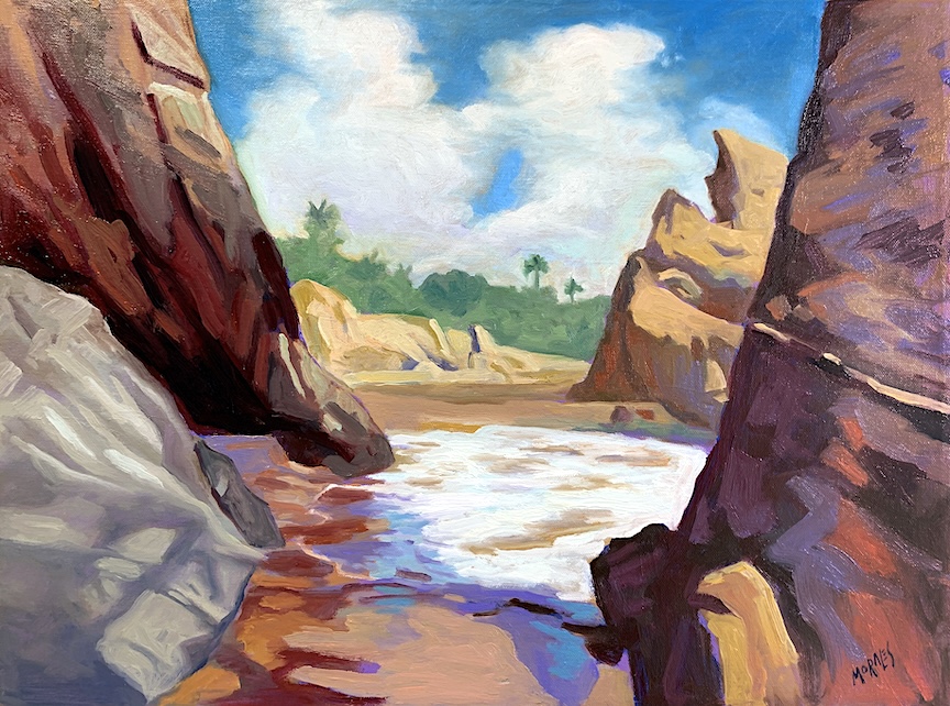 Paisaje costero con rocas y mar en movimiento bajo un cielo parcialmente nublado, evocando una sensación de tranquilidad y contemplación.